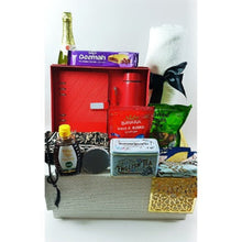 A luxurious leather box gift set with various items including Arabic written notepad, pen, temperature reading bottle, bath towel, tea, nuts, dried fruits, apple cider, date bar, honey, prayer mat, tasbih, mints, and an XL headscarf.