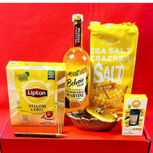 Assorted items including a bottle of Belvoir Martini, Lipton Yellow Label tea, and a bag of Peppino Sea Salt crackers on a red background.