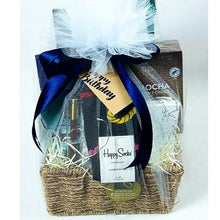Gift basket with a bottle of Baron Romero, a box of Mokate gold Latte, A mahogany pen in a gift box, Fragrance Diffuser and Happy Socks socks, wrapped with a blue ribbon.