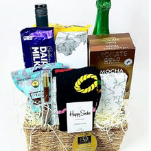 Gift basket with snacks, drinks, and a sock on a white background