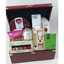 Gift set with various products including nail polish, tea, and skincare items in a decorative box.