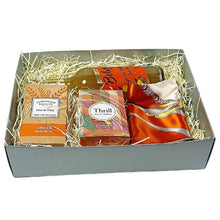 Gift box with a variety of items including a scarf, tea, perfume and cookies on a white background