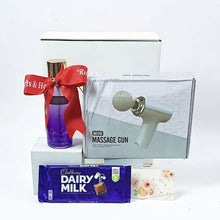 A clear display of the scarlet relief gift set. Showing the contents. A body splash, dairy milk chocolate and a mini massage gun