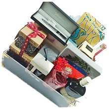 Open jewelry box with various items including a bottle, perfume, and gift boxes.