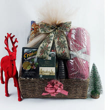 Christmas gift basket filled with gourmet treats and a fabric, towel and leatherette notepad.Wrapped up in tulle netting.