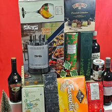 Assorted gift items including a barbecue grill, Wines, chocolate, and trearts on a leather box agaist  a red background