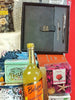 Gift basket with a notebook, pen, and various items on a red background