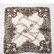 Flat lay view of the Gold Chain & Wild Ornament Silk Square Scarf featuring a gold chain center and leopard print baroque border on a clean white background.
