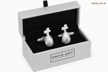 A pair of silver-toned golf ball cufflinks displayed inside an open textured gray Onyx Art London gift box with a black velvet lining, on a white background.