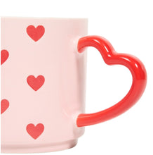 Pink mug with red heart handle and heart patterns on a white background