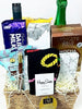 Gift basket with snacks, drinks, and a sock on a white background