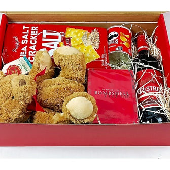 Box containing teddy bears, snacks, and a bottle of wine.
