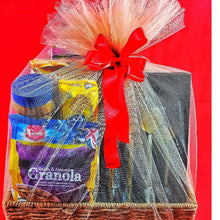 Gift basket tied in tulle netting and a red ribbon against a red backkground