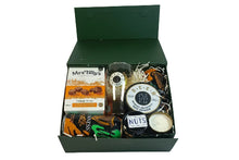 Gift box with various items including a box of Mrs. Tilly's orange purse, a glass, and a candle on a white background.