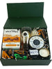 Gift box with various items including a box of Mrs. Tilly's orange purse, a glass, and a candle on a white background.