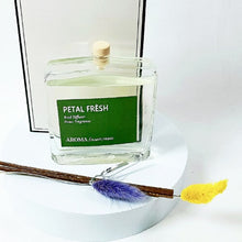 Aroma home fragrance diffuser labeled 'Petal Fresh' with a wooden stick and fluffy ends on a white background.