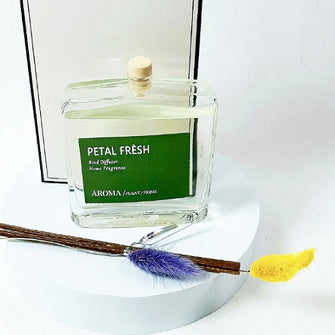 Aroma home fragrance diffuser labeled 'Petal Fresh' with a wooden stick and fluffy ends on a white background.