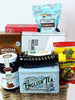Gift basket with assorted snacks and tea on a white background