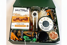 Gift box with beer-themed items including glasses, coasters, nuts , a candle and fudge.