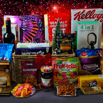A festive hamper containing a variety of food items including cereal, nuts, biscuits, chocolate, granola, and fruit sweets, all packaged in colorful Christmas-themed packaging.