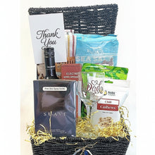 Gift basket with various items including a wine glass, snacks, and a bottle of La Motta coffee on a white background.