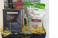 Gift basket with wine, snacks, and a bottle of Suave shampoo on a white background