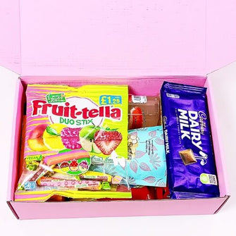 Open pink box containing Fruit-tella Duo Stix and Cadbury Dairy Milk chocolate bars on a white background.