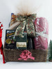 Christmas gift basket filled with gourmet treats and a fabric, towel and leatherette notepad.Wrapped up in tulle netting. 