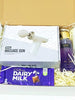 The scarlet relief box. A white and purple themed gift box containing a mini massage gub set, A victoria secrets body splash and a bar of dairy milk 110g chocolate. 