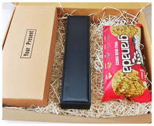 A brown gift box dressed with box fillers containing a box of socks 5 pieces, A black box with a leather bracelet and a pack of whole grain cookies