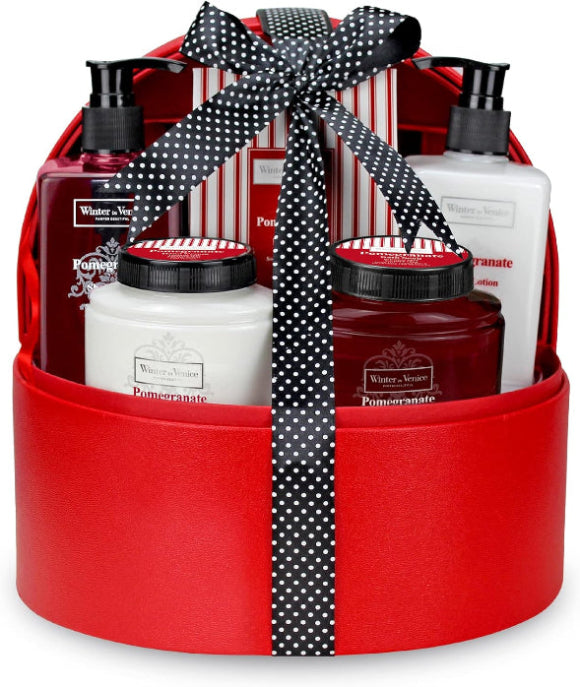 A red jewelry box with a selection of bath and body products arranged inside, tied with a black ribbon with a polka dot design. The products include bottles of shower gel, body lotion, and other skincare items.