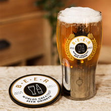 A beer glass with a gold finished base, featuring the text 'Greatest Beer Drinker', alongside a matching coaster with the same text.